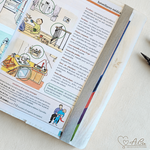 Carnet de santé ouvert avec protège carnet Rosée d’Éveil et élastique marque-page