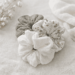 Lot de 3 chouchous en double gaze de coton aux tons doux posés sur tissu clair